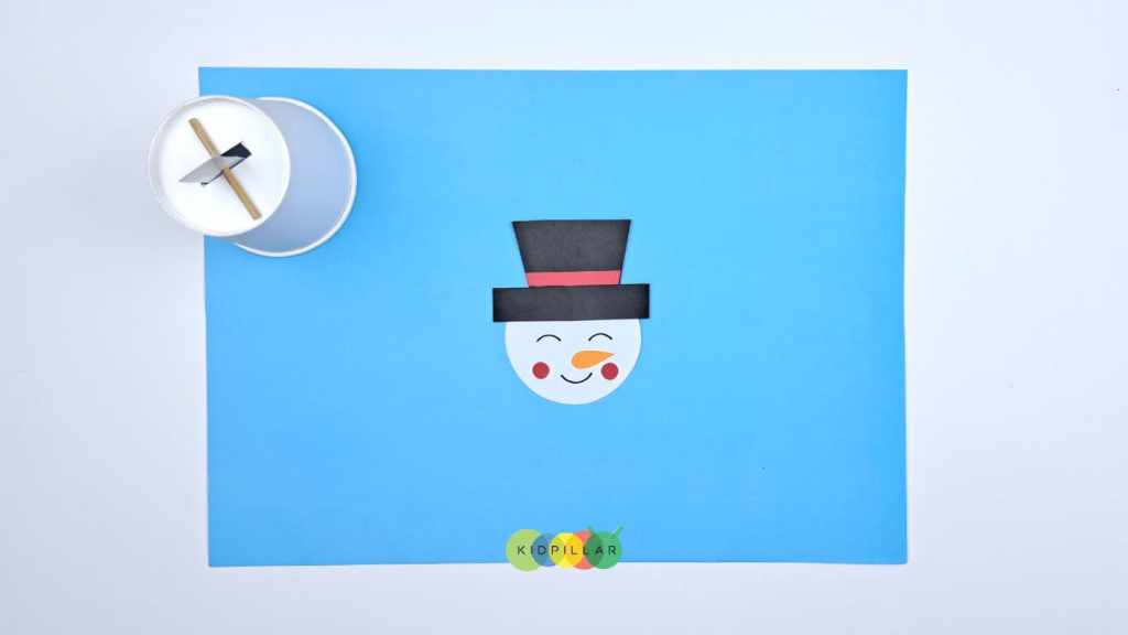 Paste the carrot nose to make paper cup snowman craft for school project