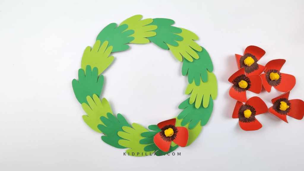 Glue the flowers on the wreath to make Poppy Wreath craft for Front Door