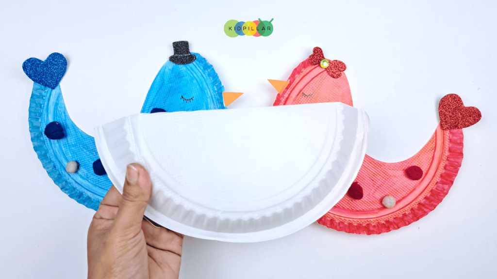 Fold paper plate into half to make rocking love birds craft for kids