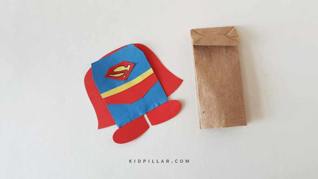 Glue the cape of the superman puppet craft for preschoolers